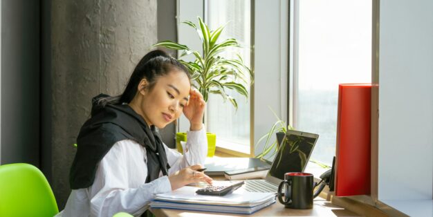 Mulher a fazer contas para somar o subsidio de desemprego ao salário